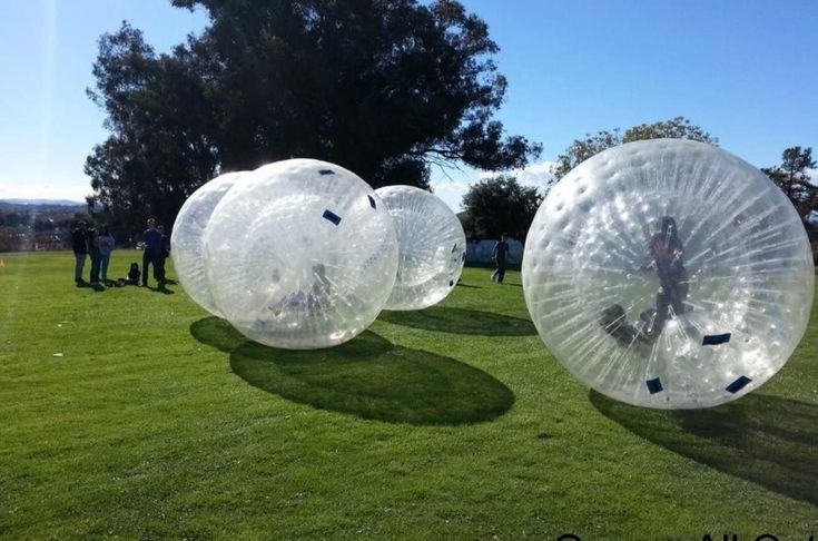 Zorbing in transparent inflatable balls on green field at Bande Falls and Resort